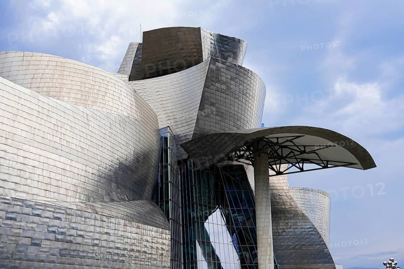 Guggenheim Museum Bilbao on the banks of the river Nervion, architect Frank O. Gehry, Bilbao, close-up of the modern art museum with curved metal walls and glass details against a cloudy sky, Guggenheim Museum, architect Frank O. Gehry, Bilbao, Bizkaia province, Basque Country, Spain, Europe