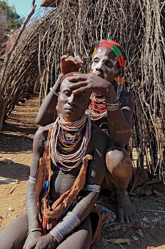 South Ethiopia, Omo region, among the Karo people, woman with jewellery and face painting styling their hair, Ethiopia, Africa