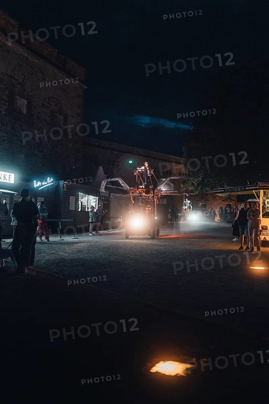Atmospheric night shot of a busy street with food trucks and passers-by. Ehrenbreitstein Fortress, Koblenz Germany