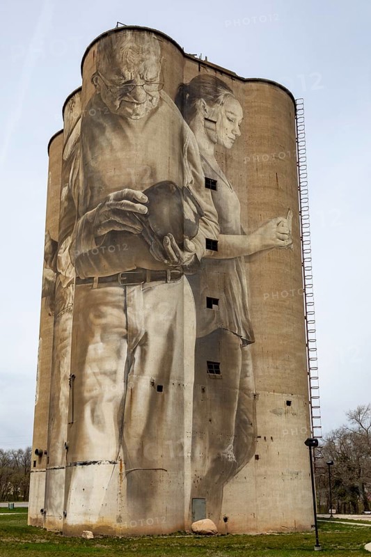 Fort Dodge, Iowa, A mural on the disused Fort Dodge Grain Terminal shows seven figures representing the people of the community. It was painted by Australian muralist Guido van Helten in 2018. Each figure carries a different stoneware object, typical of those made from the clay found in the area