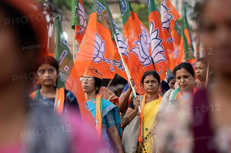 Bharatiya Janata Party (BJP) supporters holding BJP flags arrives to to see a roadshow of Union Home minister Amit Shah, ahead of third phase of General Elections, in Guwahati, Assam, India on 29 April 2024