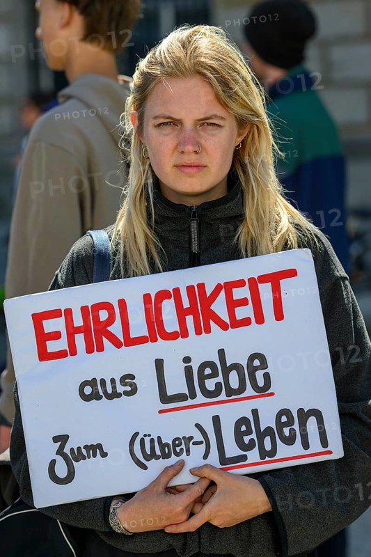 Participant in a silent demonstration for the hunger strikers. Her poster reads Honesty for the love of (survival) life . Paul Loebe House, Berlin, 12 May 2024