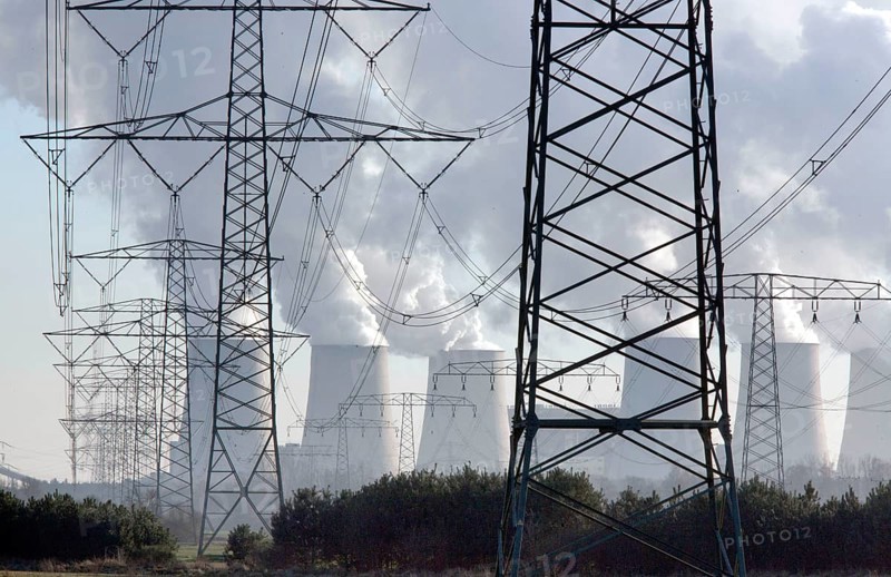 Steam rises from the cooling towers of the Vattenfall power plant in Jaenschwalde, power lines and electricity pylons at the power plant on 9 December 2014. The energy company Vattenfall mines lignite to generate electricity in the surrounding open-cast mines in Brandenburg, Jaenschwalde, Brandenburg, Germany, Europe
