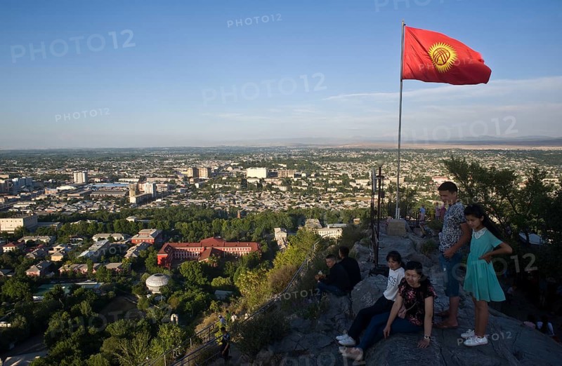 View of Osh from the sacred mountain Sulaiman too, Kyrgyzstan. The Kyrgyzstan flag is fluttering in the wind