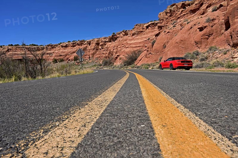 Red Ford Mustang convertible on the roadside of historic Route 66, Dead Man's Curve, New Mexico
