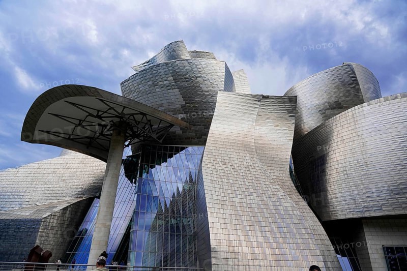 Guggenheim Museum Bilbao on the banks of the Nervion River, architect Frank O. Gehry, Bilbao, Modern building with curved metallic surfaces and large glass windows against a cloudy sky, Guggenheim Museum, architect Frank O. Gehry, Bilbao, Bizkaia Province, Basque Country, Spain, Europe