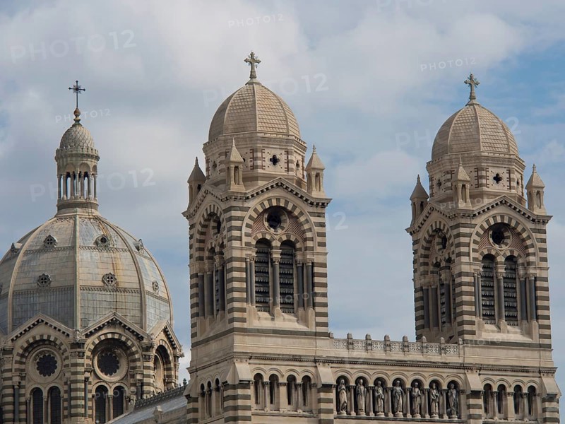 Detailed view of historic cathedral towers and dome in overcast sky, historic cathedral with two towers against blue sky, Marseille, France, Europe