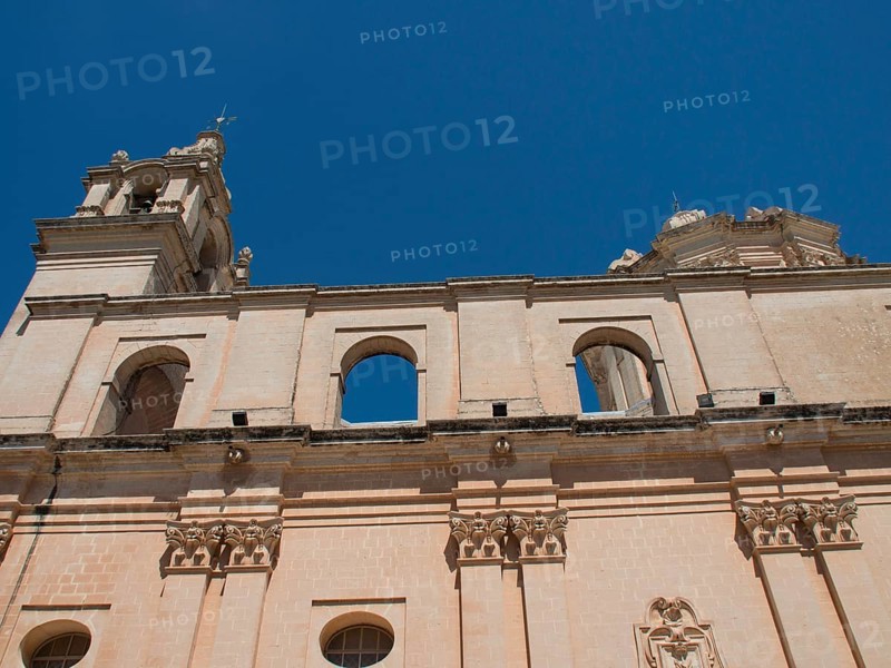 Monumental church facade with columns and decorative details under a clear sky, the town of mdina on the island of malta with historic houses, colourful balconies, magnificent churches, mdina, Malta, Europe
