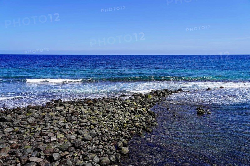 Black volcanic beach in Candelaria, Tenerife, Canary Islands, Spain, Europe, Rocky coast with gentle waves and clear blue sky, Europe