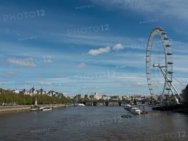 View of the River Thames in London with the London Eye and city views in the background under a slightly cloudy sky, London, England, United Kingdom, Europe