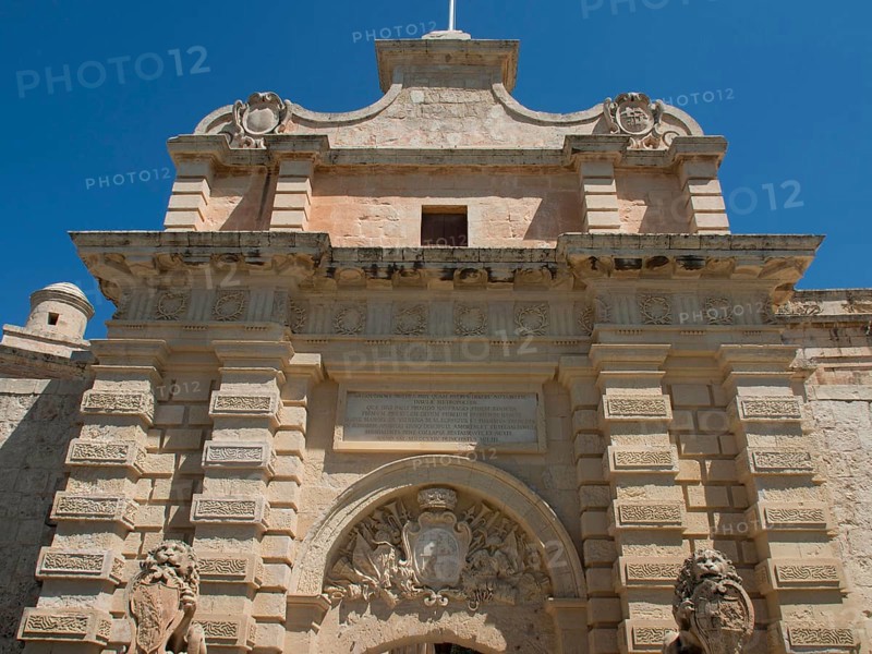 A historic Tor tor with lion sculptures and coats of arms under a blue sky, the town of mdina on the island of malta with historic houses, colourful balconies, magnificent churches, mdina, Malta, Europe