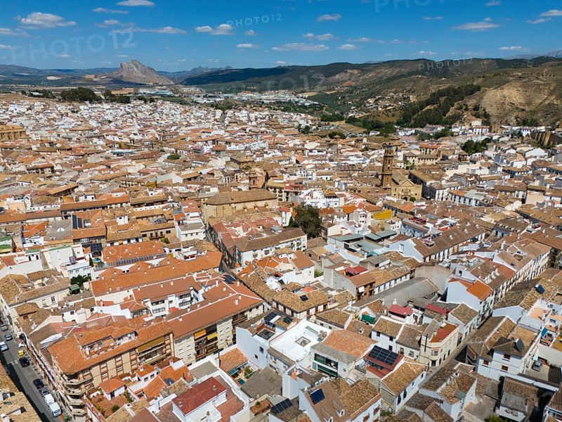 Aerial view of a Spanish town with densely packed houses and roofs, surrounded by picturesque hills and mountains, Antequera, Malaga, Andalusia, Spain, Europe