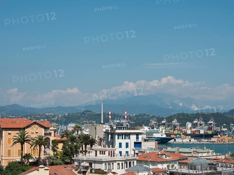 Panoramic view of a city with harbour, mountains and industrial buildings in the background under a blue sky, Bari, Italy, Europe