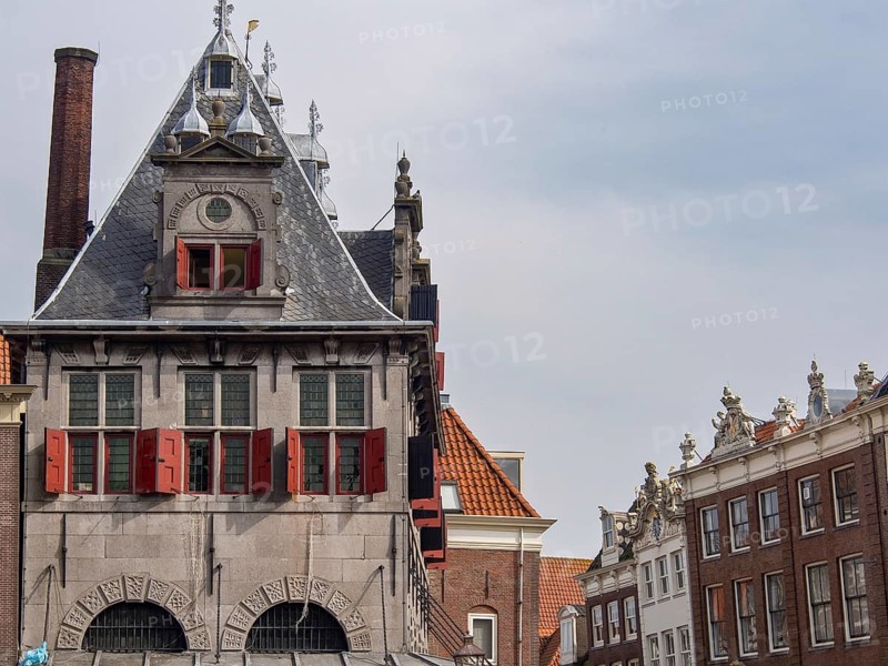 Historic building with gabled roof and red shutters in an old town, historic houses in Hoorn and ships in the harbour, hoorn, the netherlands