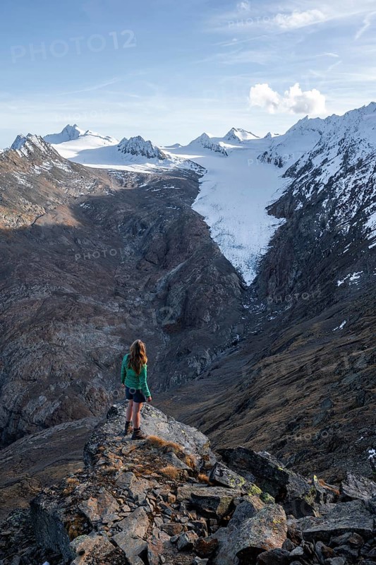Hiker looking at mountain panorama and glacier, view of Gurgler Ferner with summit Hochwilde and Falschungsspitze, Oetztal Alps, Tyrol, Austria, Europe