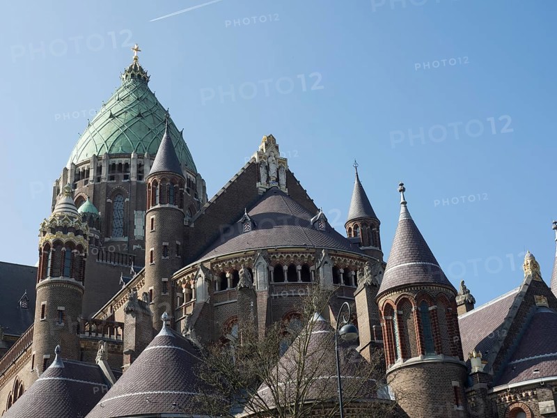 An impressive cathedral with a green dome and Gothic architecture under a blue sky, Haarlem, Netherlands