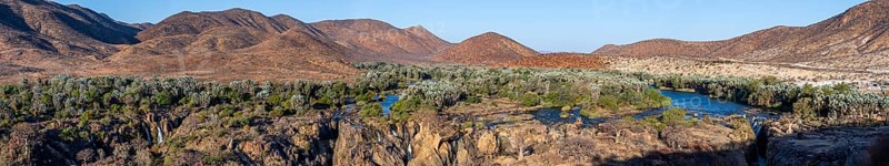 Panorama, Kunene River with green vegetation in dry red mountain landscape, waterfall and African Baobab (Adansonia digitata), in the evening light, Epupa Falls, Kunene, Namibia, Africa