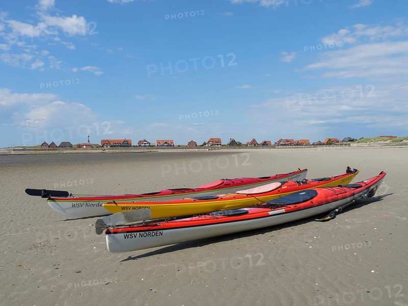 Kayaks on the beach with village in the background, Baltrum Germany