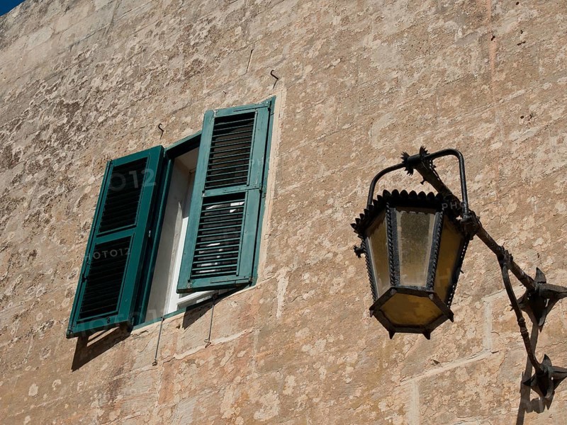 Open window with green shutters and old lantern on a stone wall, the town of mdina on the island of malta with historic houses, colourful balconies, magnificent churches, mdina, Malta, Europe