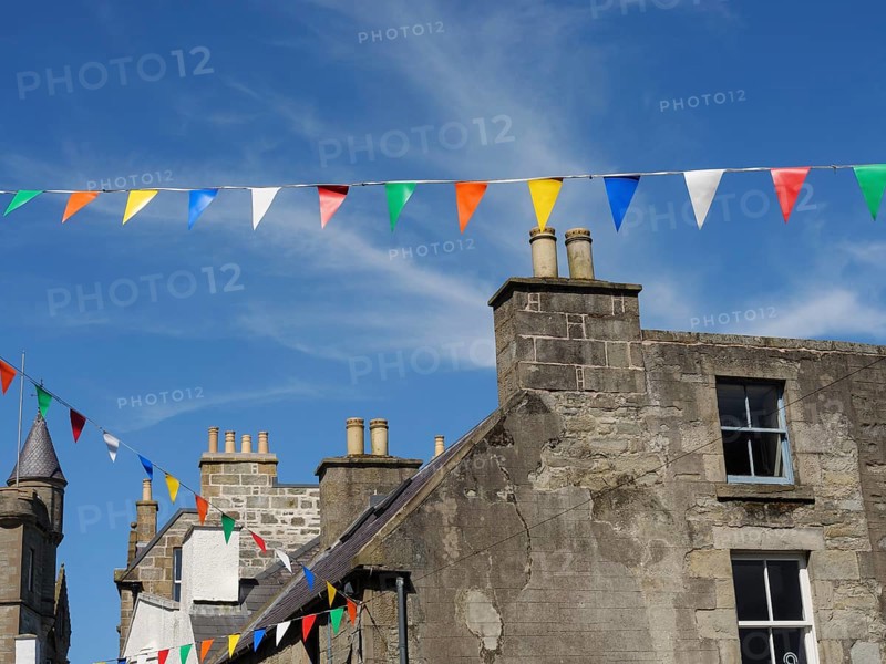 Old village houses with colourful pennants on a sunny day with a bright blue sky, grey houses with colourful flags in a seaside town, lerwick, Scotland, United Kingdom, Europe