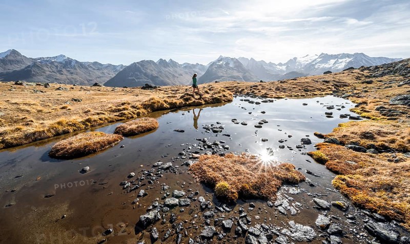 Mountaineers at a small lake on the high plateau of the Gurgler Seenplatte, glaciated mountain peaks in the background, in autumn, Sonnenstern, near Obergurgl, Oetztal Alps, Tyrol, Austria, Europe