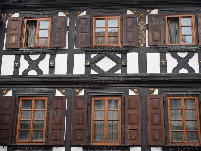 Traditional half-timbered house with dark wood structure and brown shutters in symmetrical design, kandel, germany