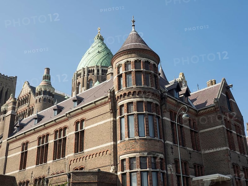 Historic Gothic church with imposing towers and multiple windows under a clear blue sky, Haarlem, Netherlands