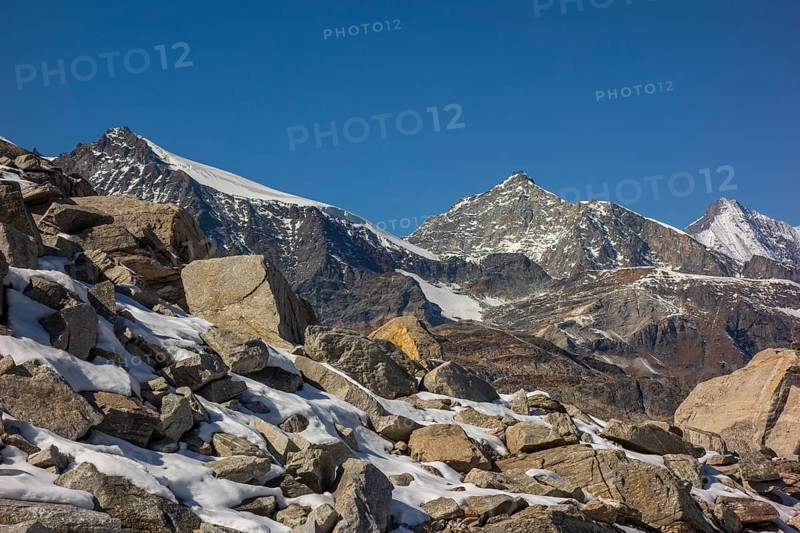 Striking mountain peaks and rock formations covered with snow under a bright blue sky, bare mountain peaks with blue sky, saas fee, switzerland