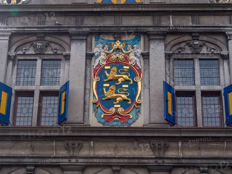 Coat of arms decorated building facade with windows and ornate architectural details, historic houses in Hoorn and ships in the harbour, hoorn, the netherlands