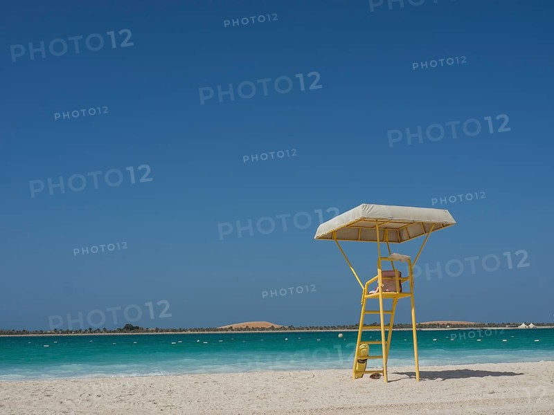 Abandoned lifeguard tower on a deserted beach with blue sky and calm sea, Abu Dhabi, Arab Emirates