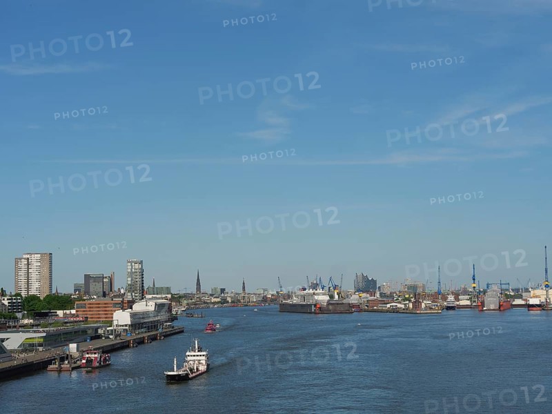 Panoramic view of an urban harbour landscape with boats and cranes under a blue sky, a picturesque city on the river with harbour, shipyards, houses and ships, Hamburg, Germany, Europe