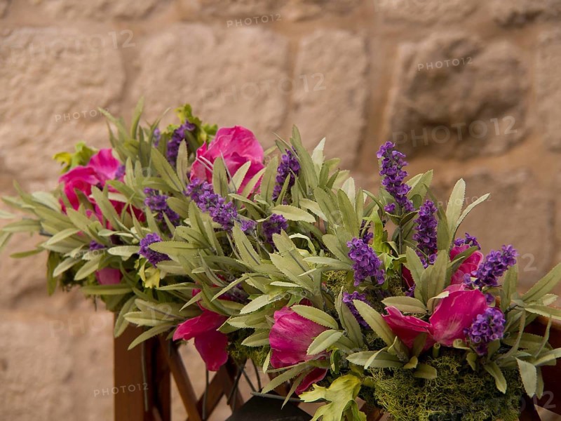 Flower decoration with lavender and pink flowers against a stone background, the old town of Dubrovnik with historic houses, churches, red roofs and fortress walls, dubrovnik, coratia
