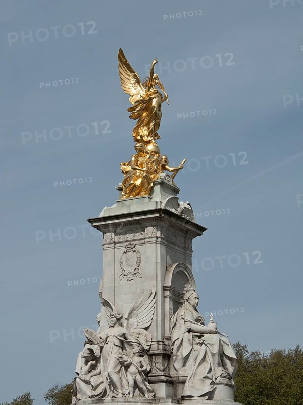 Golden angel statue rises on a marble pedestal, blue sky in the background, London, England, Great Britain