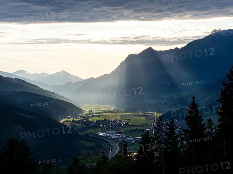 Sunlight falls on the Liesingtal valley and the village of Traboch, Schoberpass federal road, view from the lowlands, Leoben, Styria, Austria, Europe