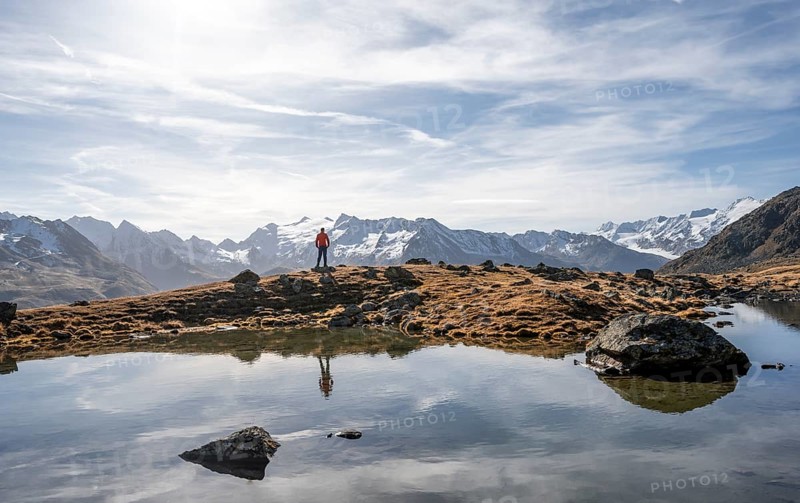 Mountaineers at a small lake on the high plateau of the Gurgler Seenplatte, glaciated mountain peaks in the background, in autumn, Sonnenstern, near Obergurgl, Oetztal Alps, Tyrol, Austria, Europe