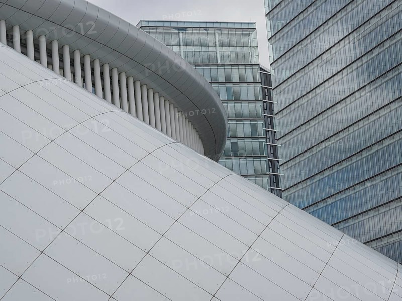 Architecturally modern building with white structure and neighbouring office towers in Luxembourg, modern buildings with treetops and glass facades, luxembourg