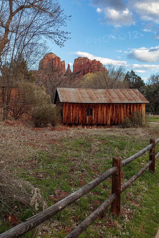 Cathedral Rock sandstone formations tower over a rustic barn at the Crescent Moon Picnic Site in Sedona, Arizona, United States of America, USA, North America