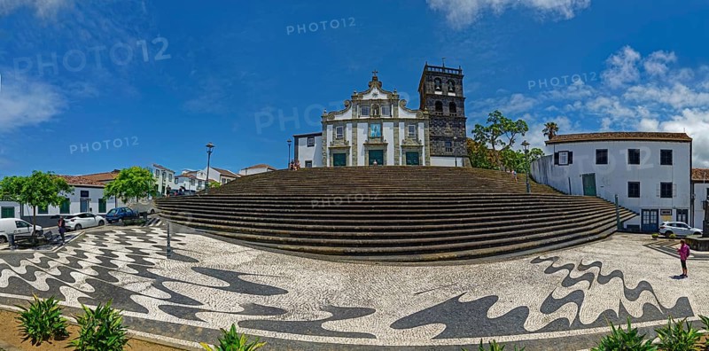 Panoramic view of the historic church Igreja Matriz de Nossa Senhora da Estrelwith large steps and unique architecture, towering over a spacious square under a sunny sky, coastal town of Ribeira Grande, Santa Barbara, Sao Miguel, Azores, Portugal, Europe