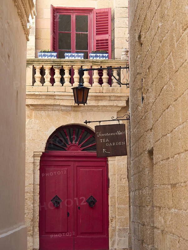 Narrow alley with a red door, a window and balconies above, the town of mdina on the island of malta with historic houses, colourful balconies, magnificent churches, mdina, Malta, Europe