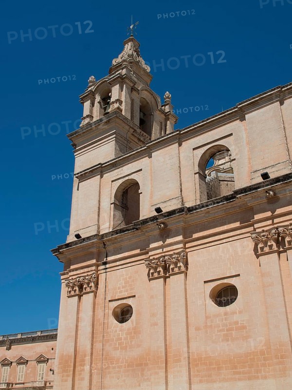 A tall church tower and sand-coloured buildings under a clear blue sky, the town of mdina on the island of malta with historic houses, colourful balconies, magnificent churches, mdina, Malta, Europe