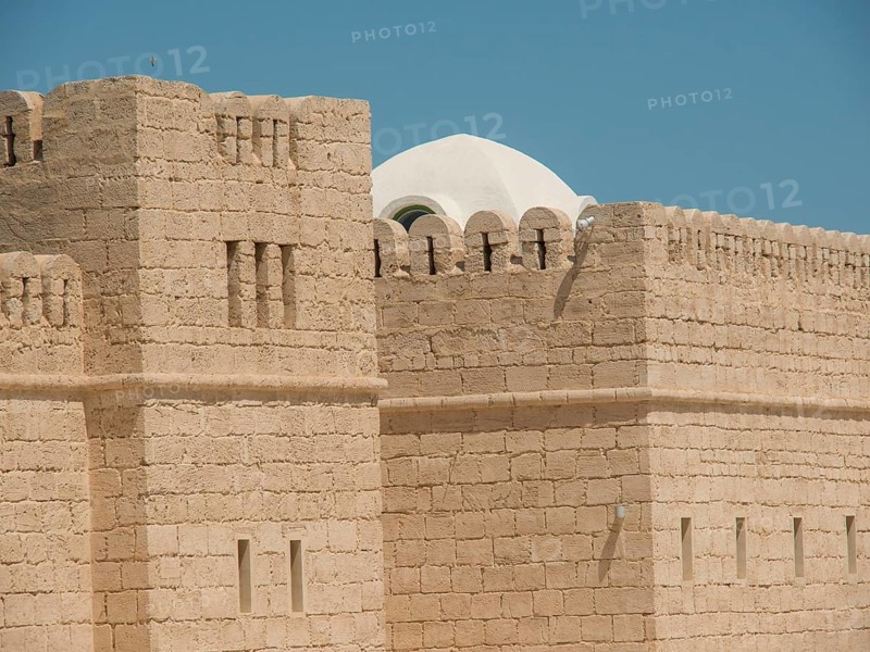 Stone walls of a historic fortress or castle with dome and clear sky, Tunis in Africa with ruins from Roman times, modern mosques and blue and white houses in sidi-bou-said, Tunis, Tunisia, Africa