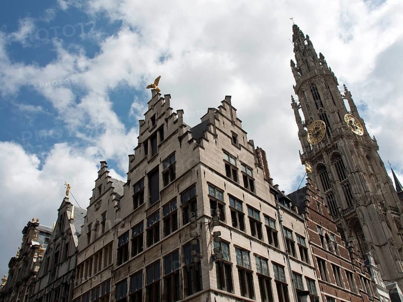 Historic buildings with ornate gables and a bell tower in the background under a blue sky with clouds, Historic buildings, Antwerp, Belgium, Europe