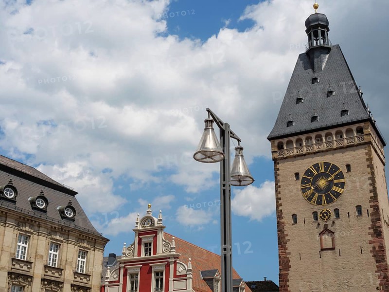A clock tower and neighbouring historic building complemented by a modern lantern against a cloudy sky, tower with clock tower in front of historic houses, Speyer, Germany, Europe