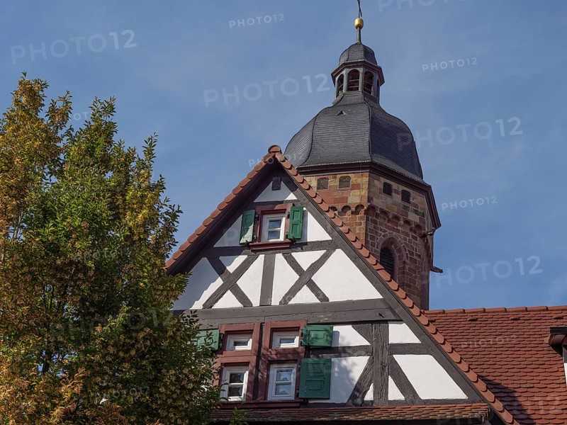 Church and half-timbered house with bell tower under a clear autumn sky, historic half-timbered houses in the Palatinate, kandel, Germany, Europe