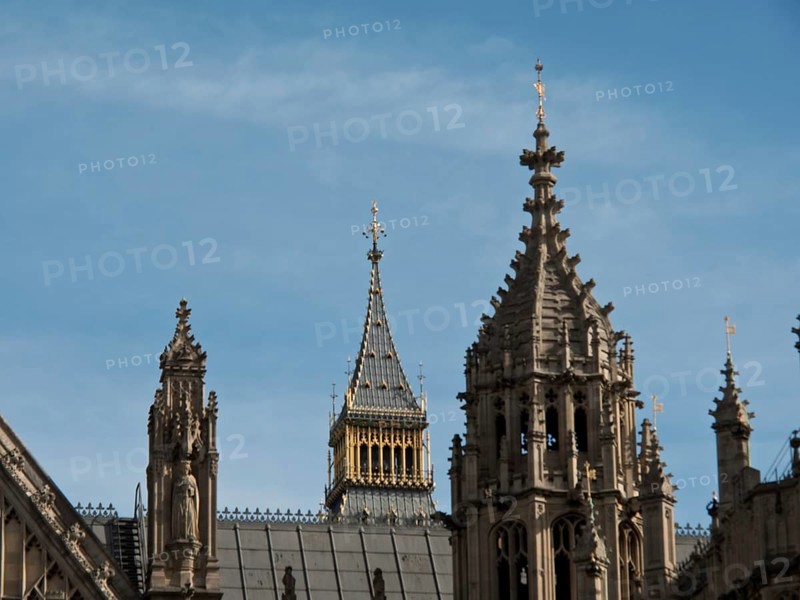 Detail of a gothic building with towers and roof spires, smaller tower in the background, blue sky, London, England, Great Britain