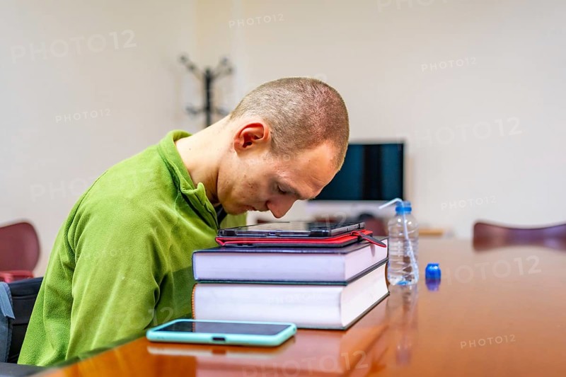 Man with cerebral palsy studying in a quiet room in the university