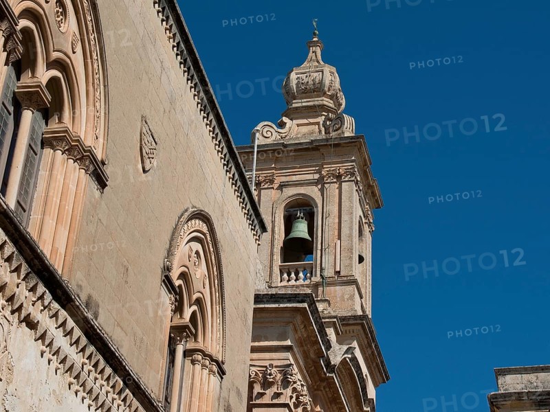 Baroque elements of a historic church tower with bell and decorated facade, Historic buildings with beautiful windows, balconies and small towers, Mdina, Malta, Europe