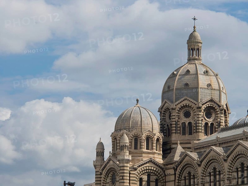 Close-up of a historic cathedral with large domes under a clear sky and some clouds, historic cathedral with two towers against a blue sky, Marseille, France, Europe