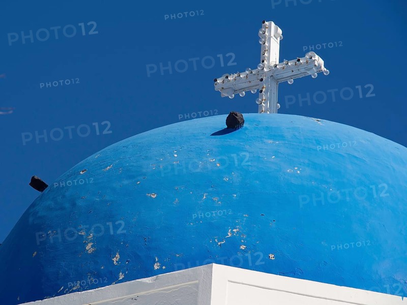 Blue dome with a white cross on a mediterranean church building, The volcanic island of Santorini with blue and white houses and churches, flowers and palm trees on a volcanic island, santorini, greece