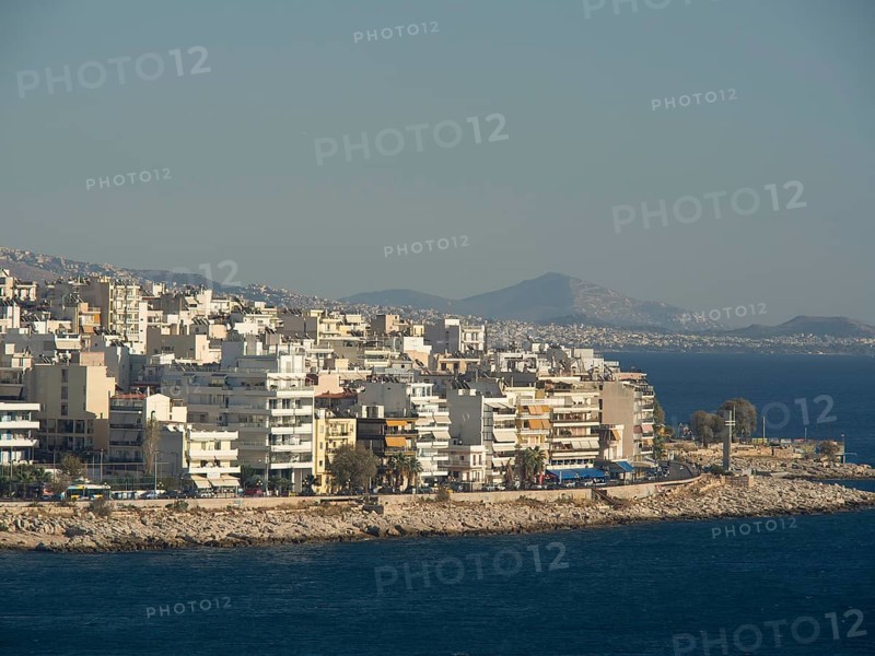 Several residential buildings along a rocky coast, with mountains in the background and a view of the sea, Ancient buildings with columns and trees on the Acropolis in Athens against a blue sky, athens, greece